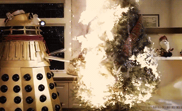 A Dalek setting fire to a Christmas Tree